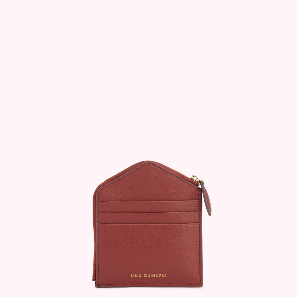 Red leather Lulu Guinness zip-around cardholder against a white background.
