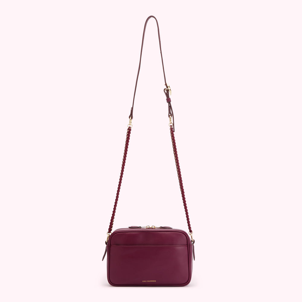 Burgundy Lulu Guinness crossbody bag with braided chain strap.
