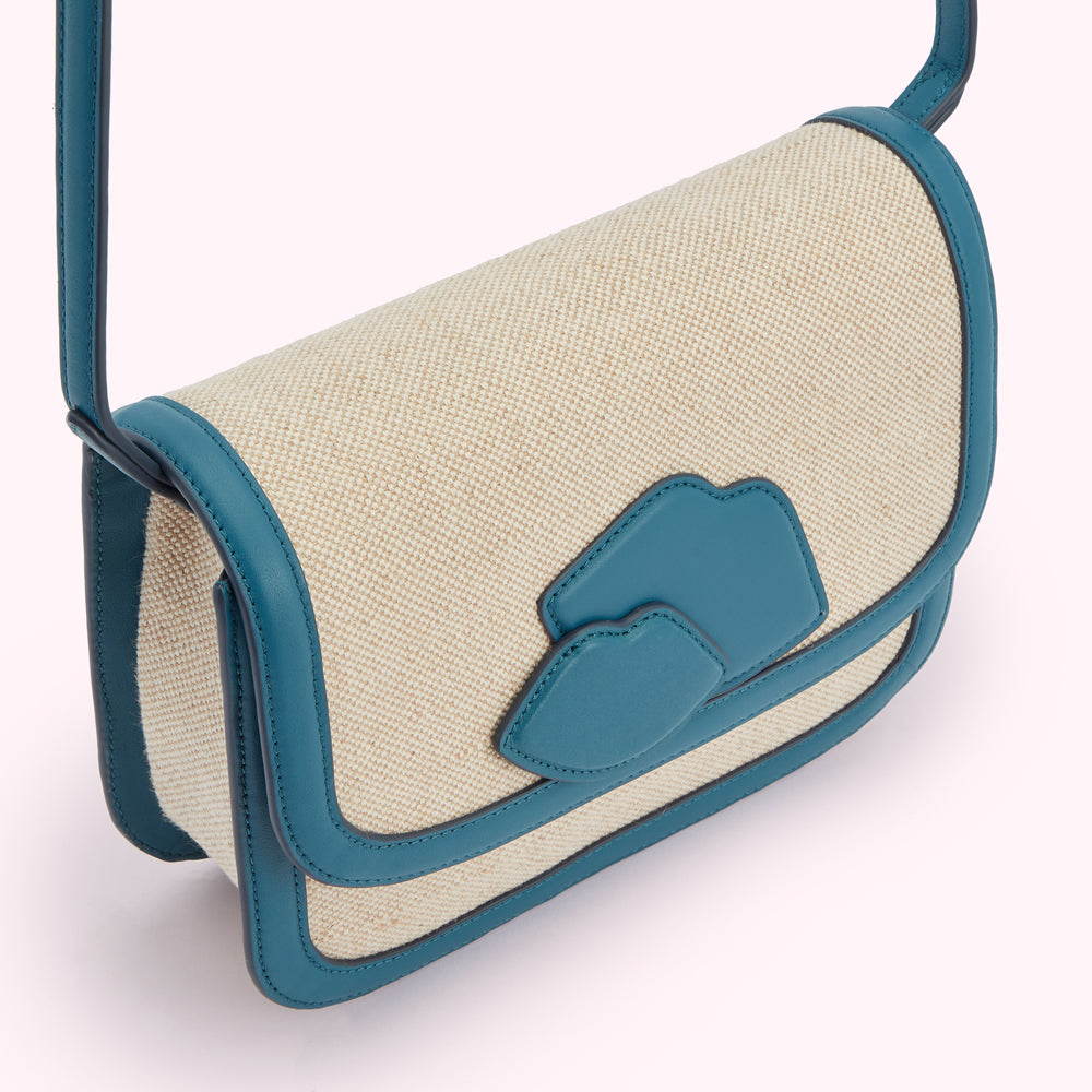 Beige canvas crossbody bag with teal leather trim and lip-shaped details.
