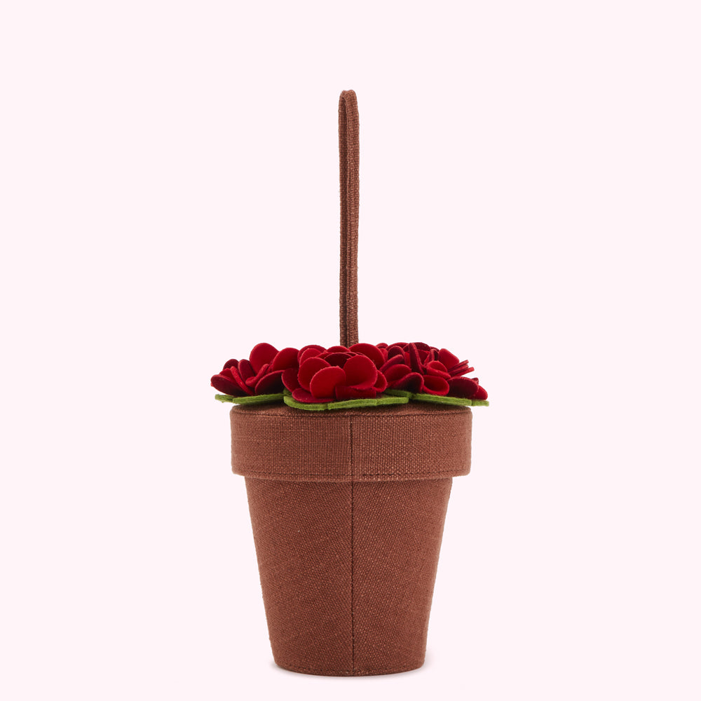 Brown flowerpot-shaped handbag with red felt flowers and a brown handle.