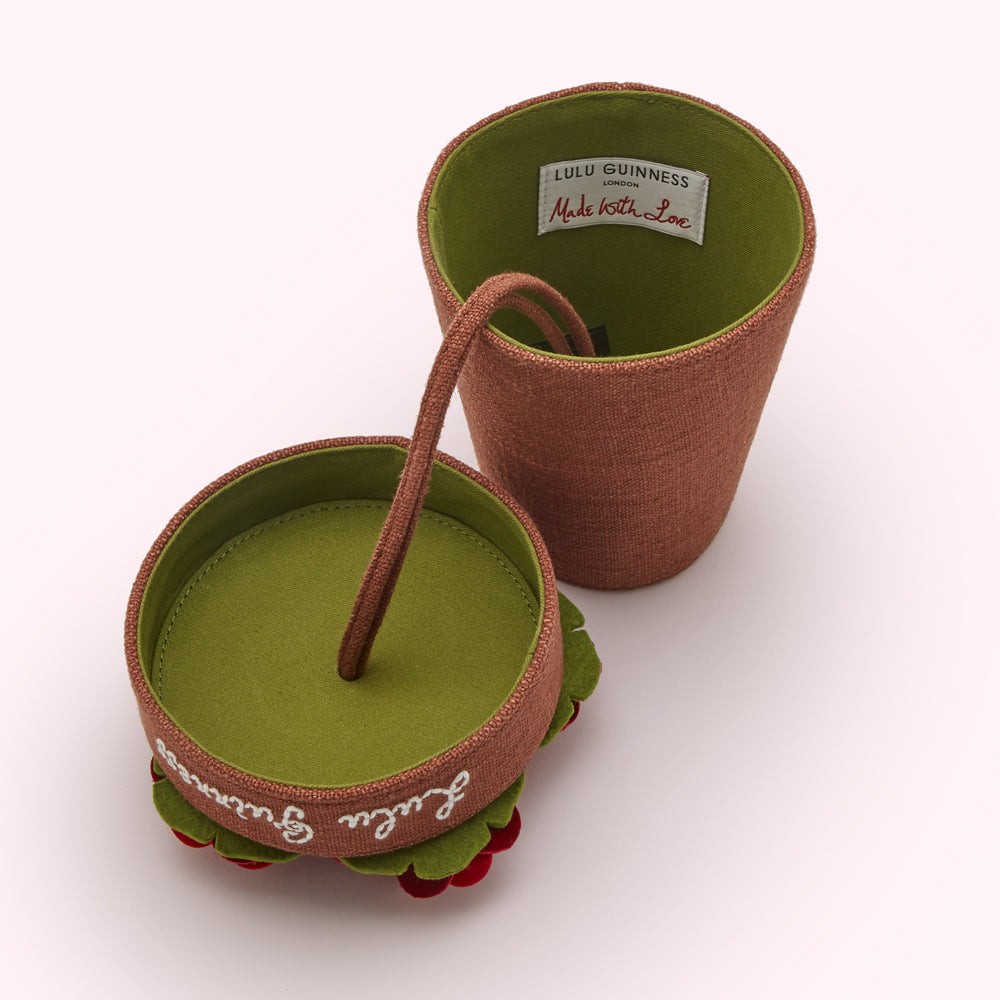 Lulu Guinness plant pot bag open, showing a green felt interior with "Lulu Guinness" and "Made with Love."