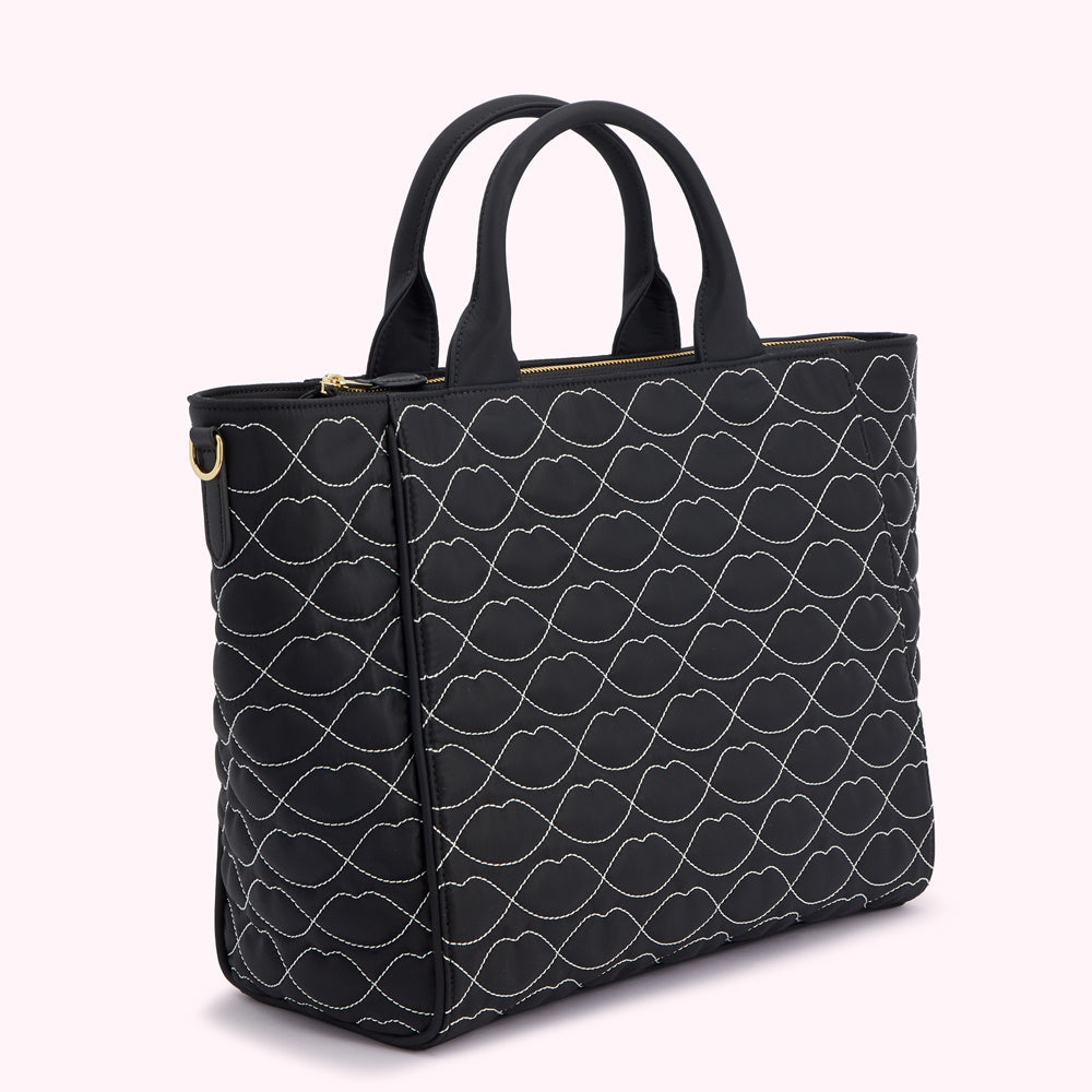 Black quilted tote bag with white lip print.