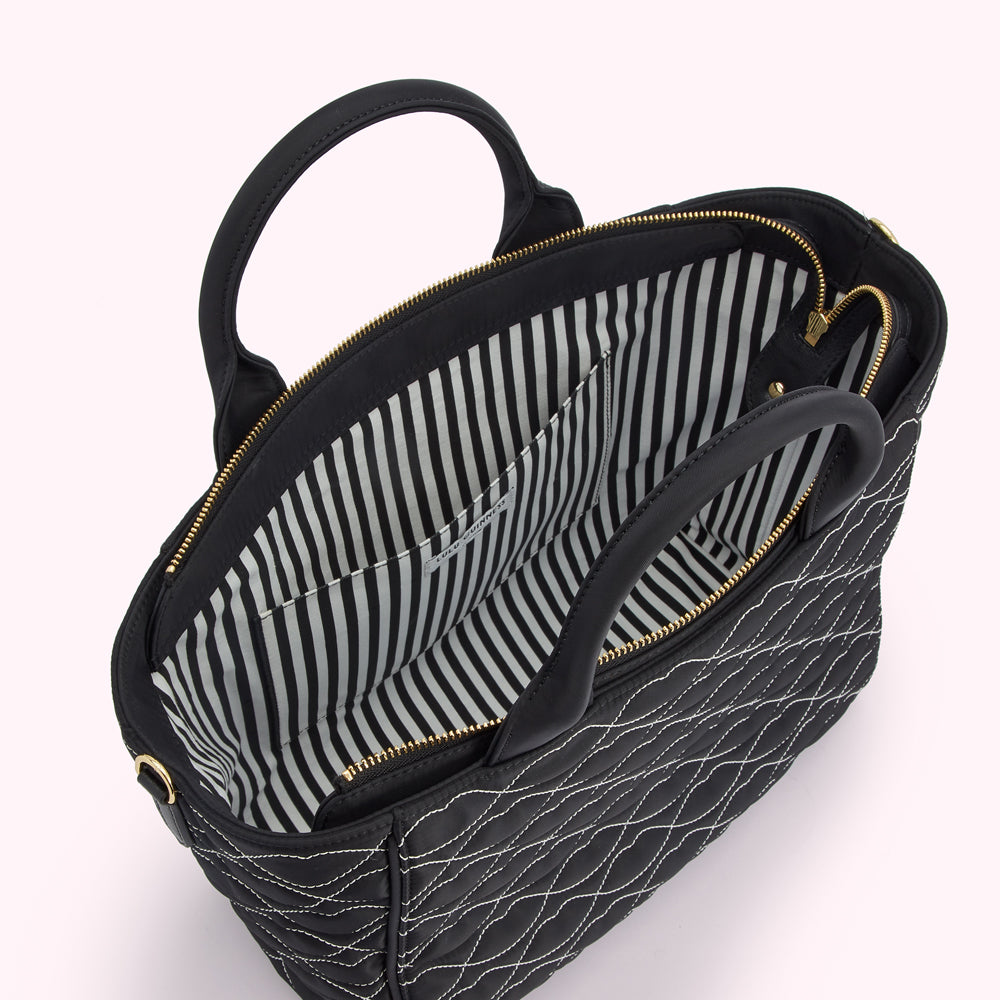 Black quilted handbag with gold zipper and striped interior lining, shown open.