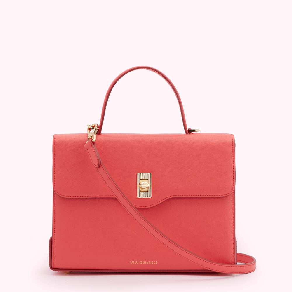 Coral Lulu Guinness satchel bag with gold clasp and shoulder strap.
