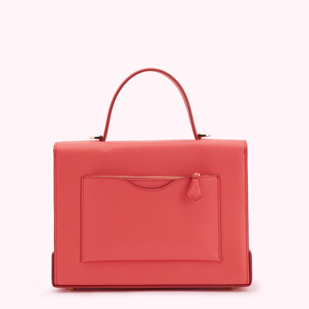 Coral-coloured leather handbag with a top handle and a front zippered pocket, shown from the back against a white background.

