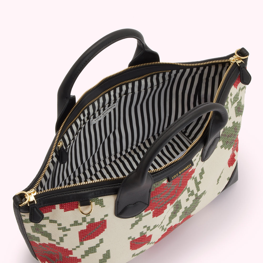Open Lulu Guinness tote bag with cream and red floral pattern and black striped interior.