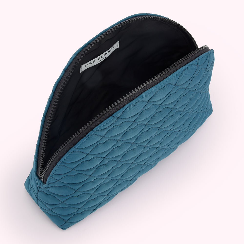 Teal quilted makeup bag by Lulu Guinness, open to reveal black interior and zipper.