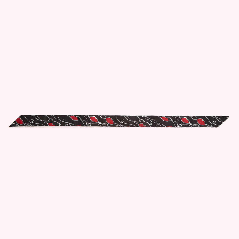 Black scarf with a pattern of red lips and white dots.
