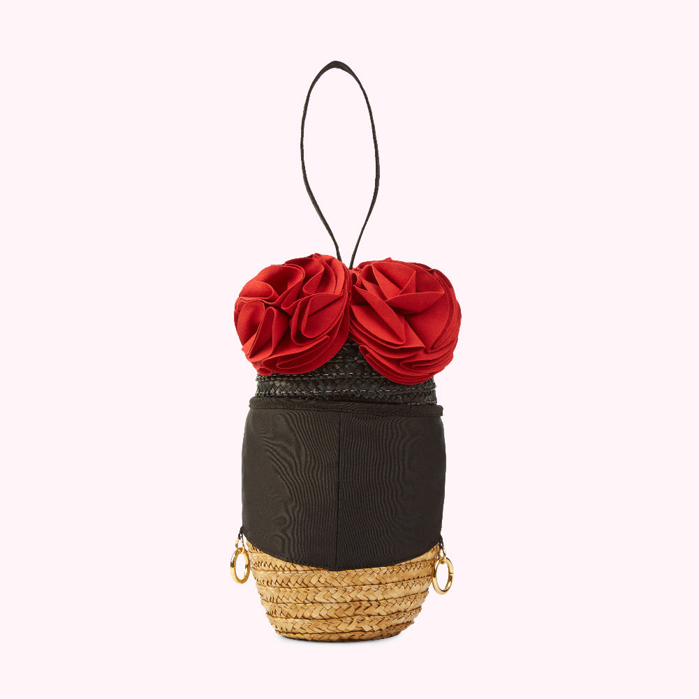 Black and beige raffia handbag with red fabric rose detail and black top handle.

