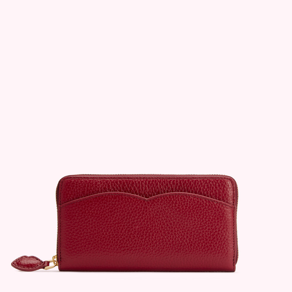 Red leather zip-around wallet with a heart-shaped zipper pull.
