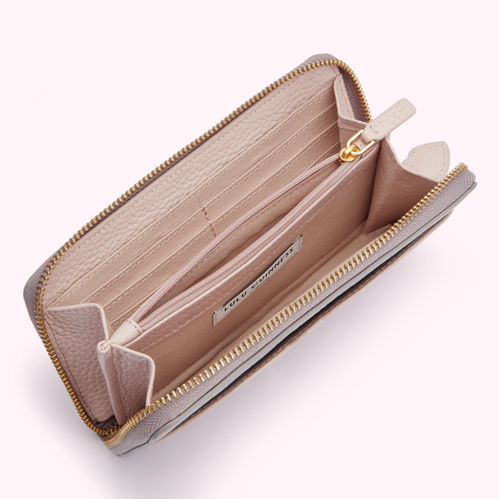 Open blush pink Lulu Guinness zip-around wallet with multiple card slots and compartments.
