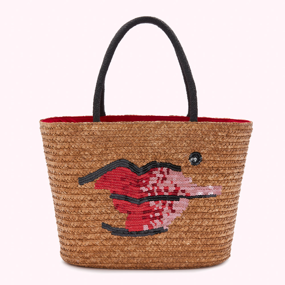 Tan straw tote bag with black handles and sequined lips design.