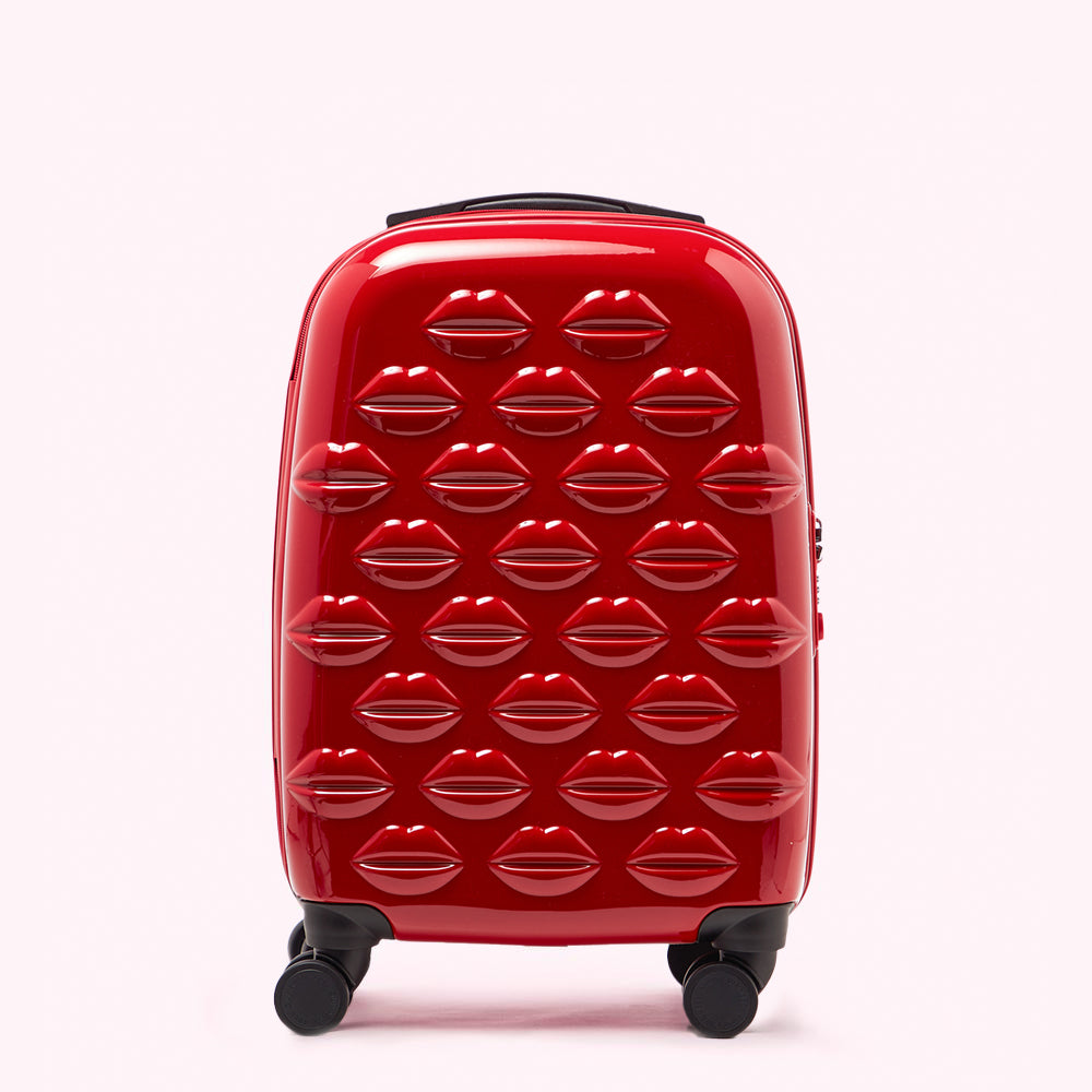 Red suitcase with lip print design on a white background.
