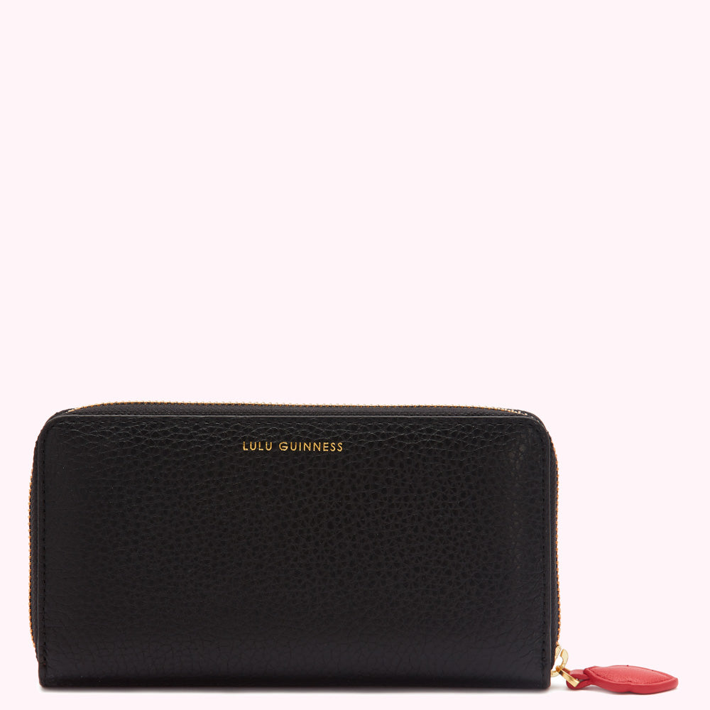 Black Lulu Guinness zip-around wallet with gold logo and red zipper pull.
