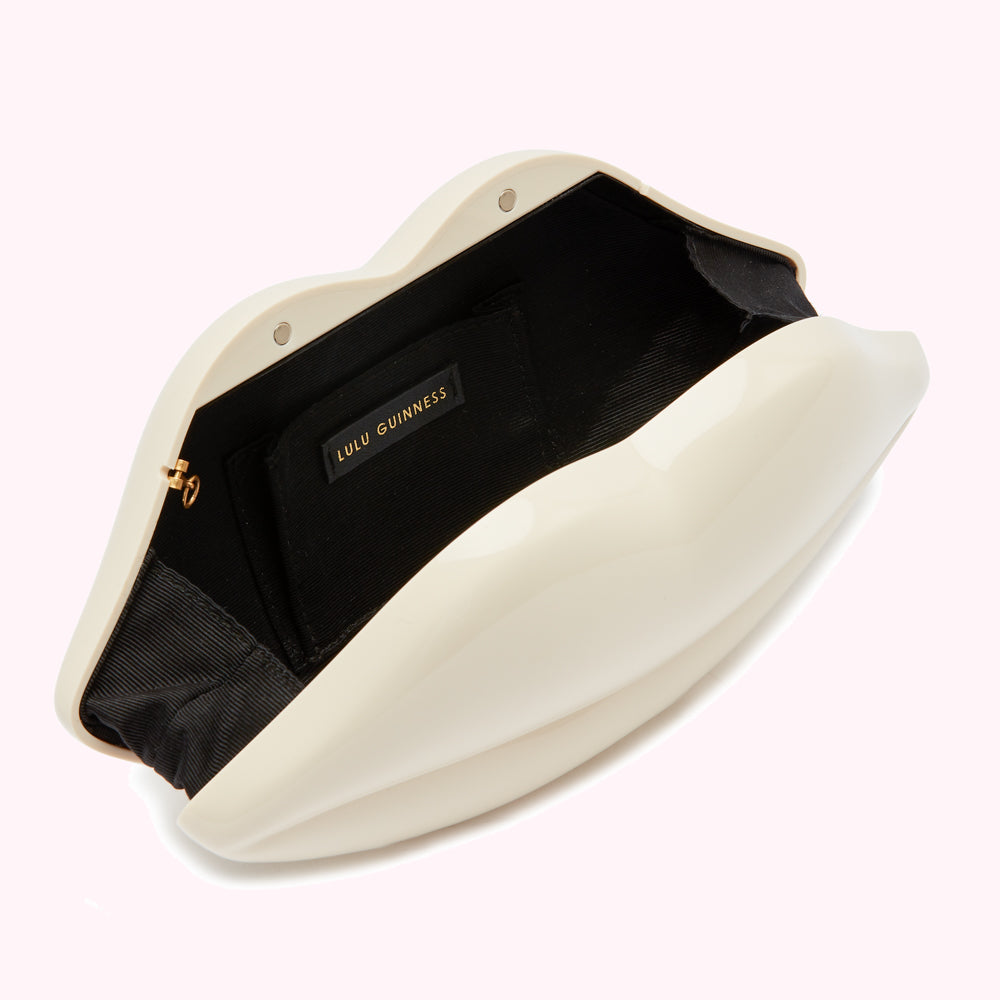 Off-white Lulu Guinness lip-shaped clutch open to reveal black interior.
