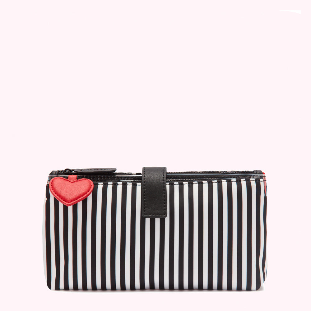 Black and white striped makeup bag with a red heart charm.
