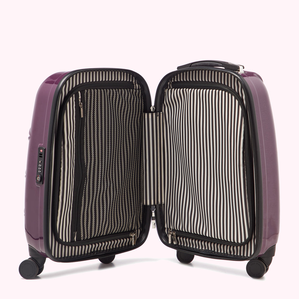 Purple suitcase open to reveal black and white striped interior lining and various compartments.
