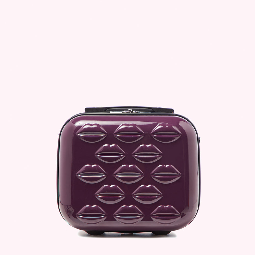 Purple carry-on suitcase with lip-shaped embellishments.
