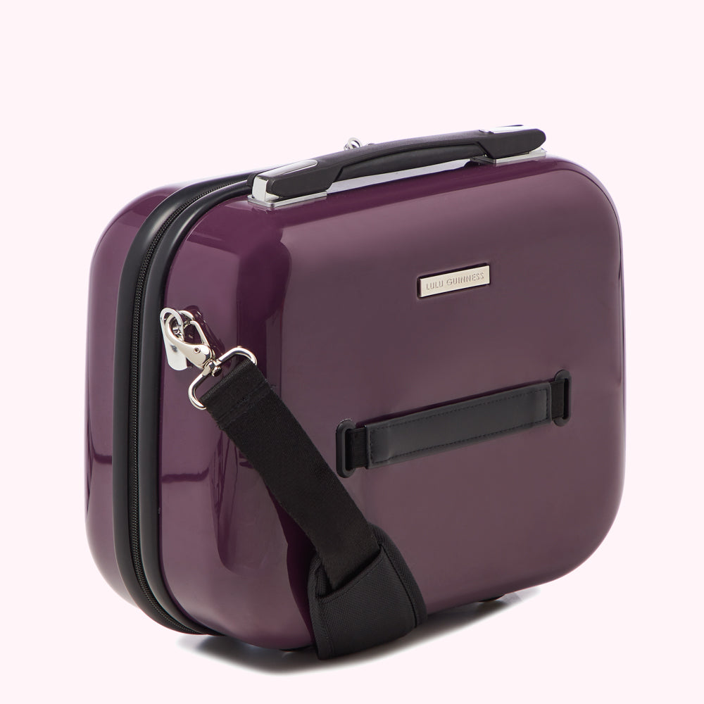 Purple Lulu Guinness vanity case with black strap.
