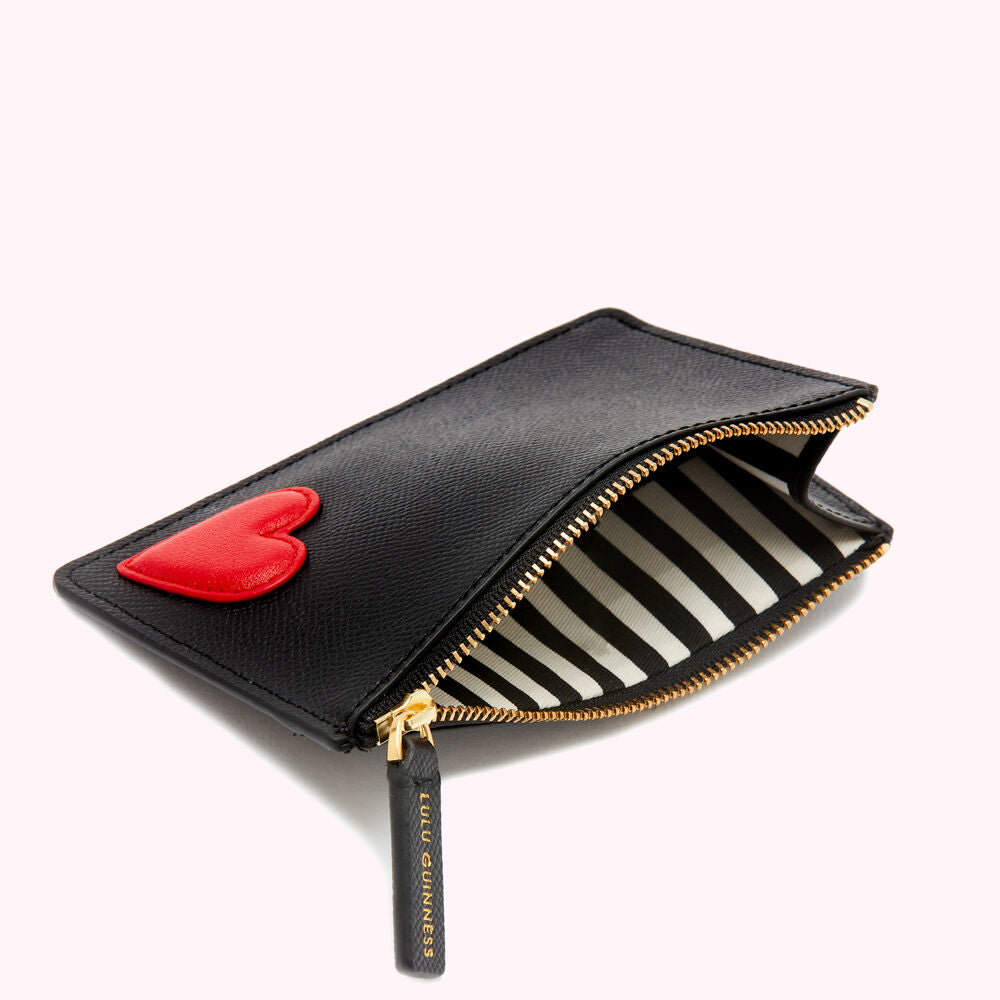 Black leather zip pouch with a red heart detail and black and white striped interior. Lulu Guinness branding on the zipper pull.
