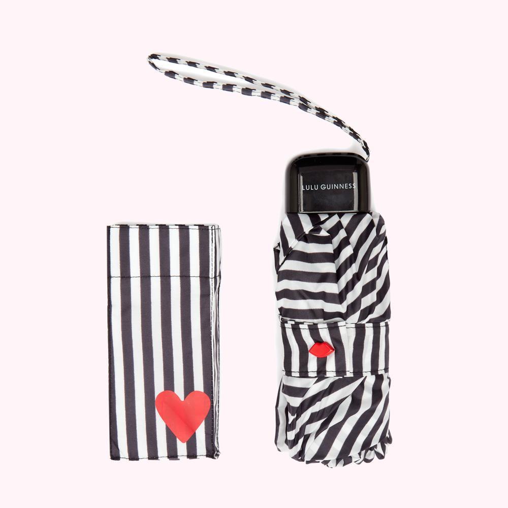 Compact Lulu Guinness umbrella with black and white stripes, red lips, and heart details, and matching case.