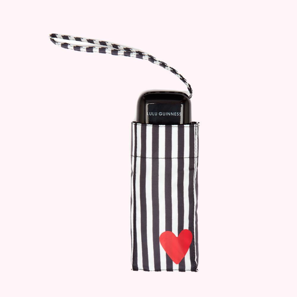 A black and white striped Lulu Guinness compact umbrella with a red heart.
