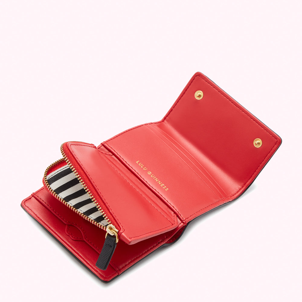 Open red Lulu Guinness wallet with black and white striped zipper.
