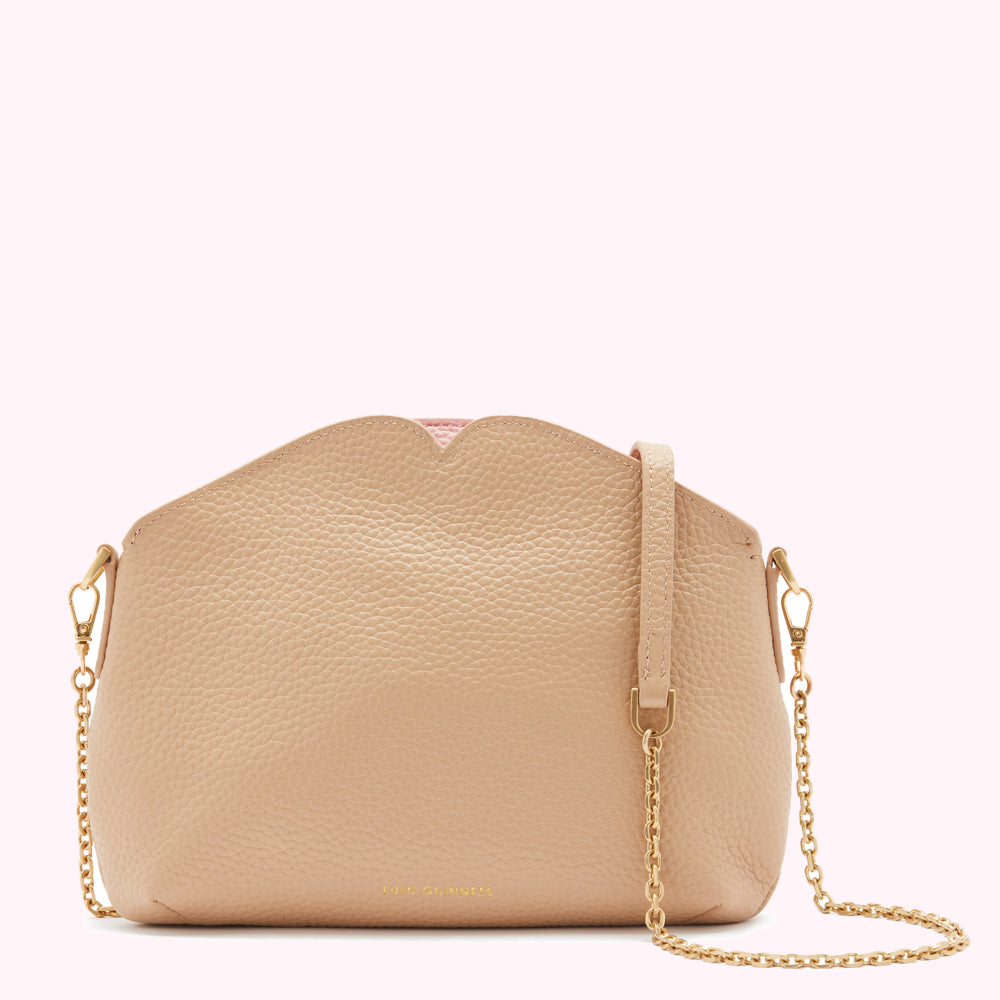Beige textured leather crossbody bag with a scallop top and a light pink interior detail. The bag has a gold chain strap.
