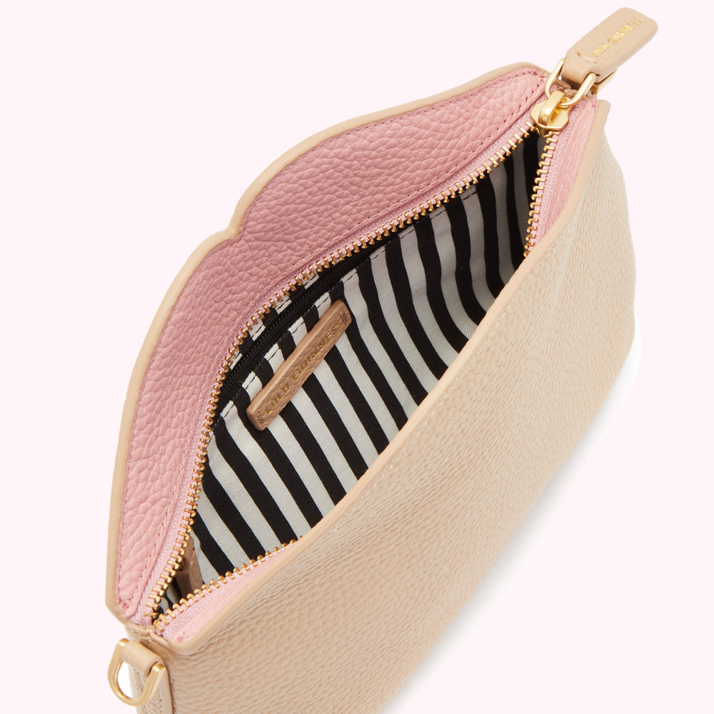 Beige and pink scalloped purse open to reveal a black and white striped interior.