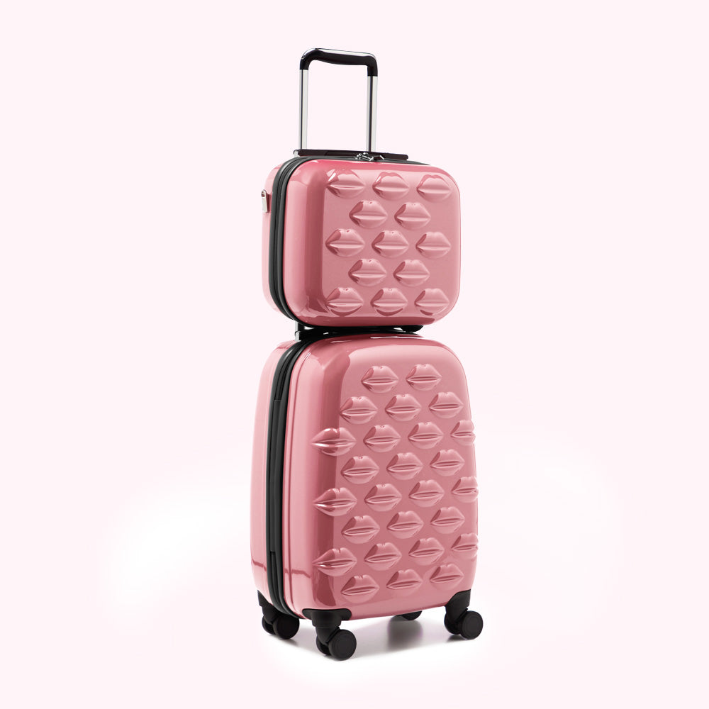 Pink luggage set with lip print design, consisting of a carry-on and a larger suitcase stacked on top of each other.
