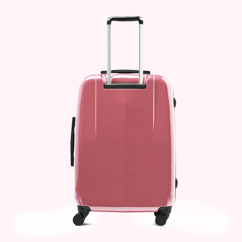 Pink suitcase with black handles and wheels against a white background.
