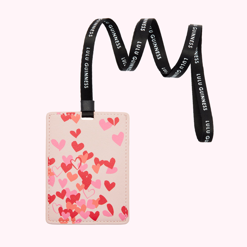 Pink card holder with a heart pattern, attached to a black Lulu Guinness lanyard.
