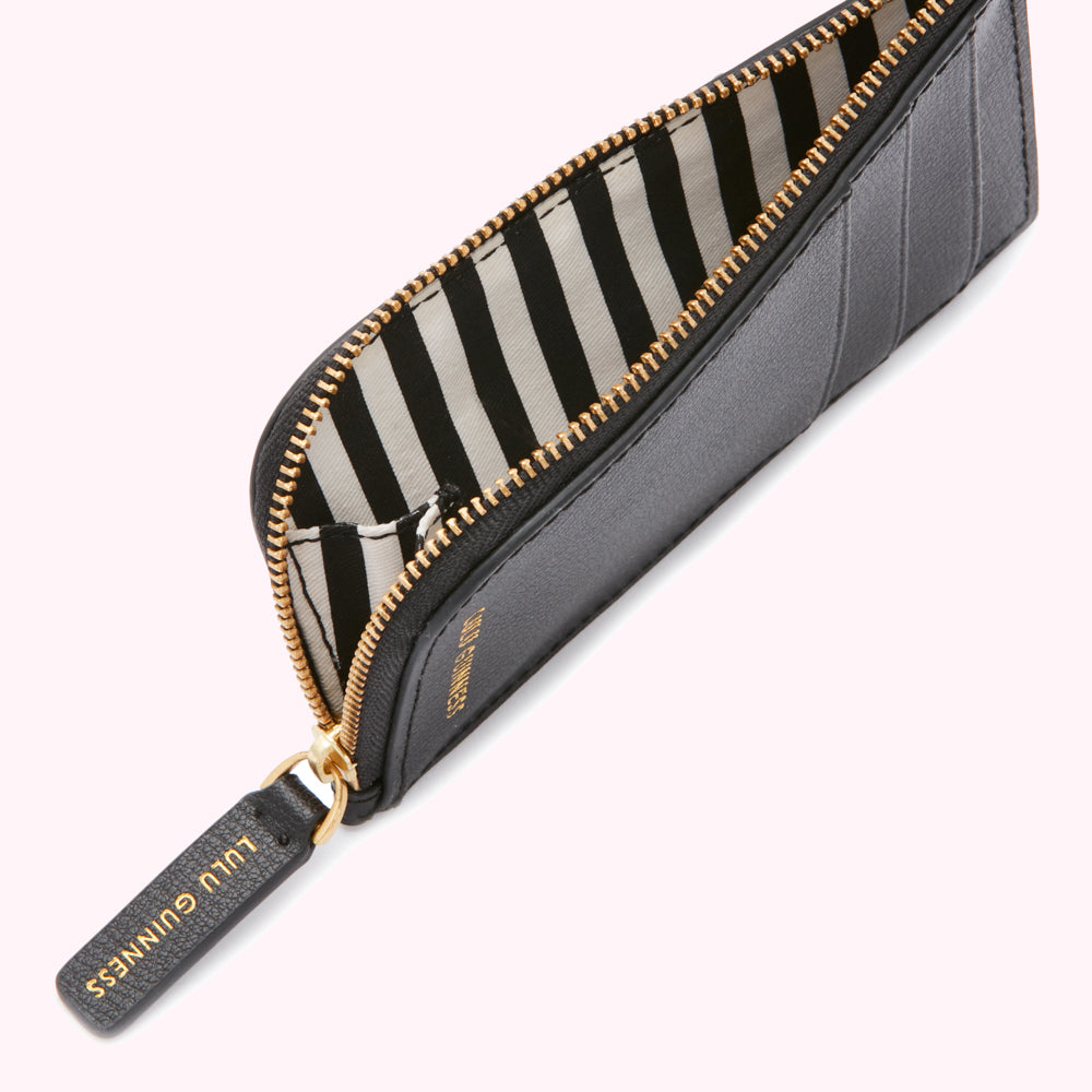 Close-up of a black Lulu Guinness zip-around cardholder with a black and white striped interior.
