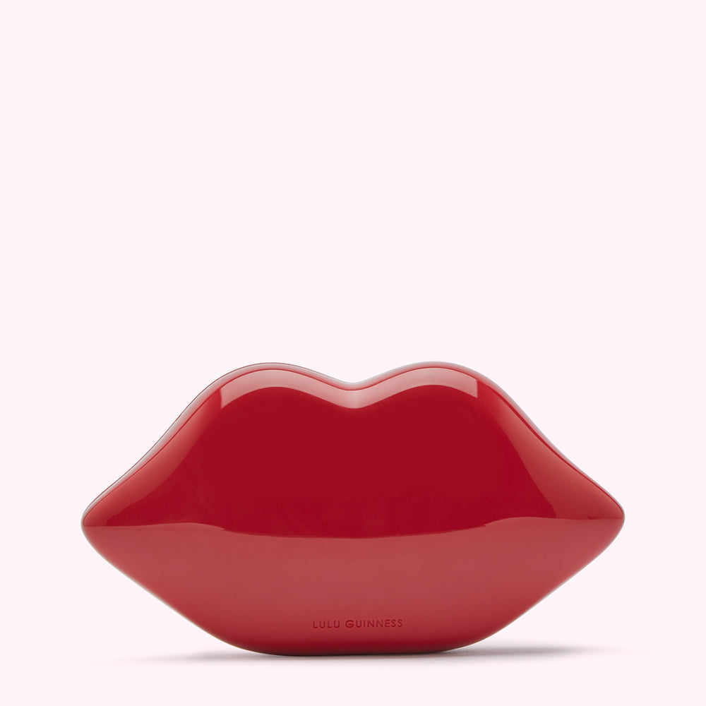 Red lips clutch purse by Lulu Guinness on white background.
