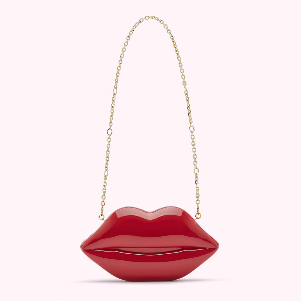 Red lip-shaped clutch with gold chain strap.
