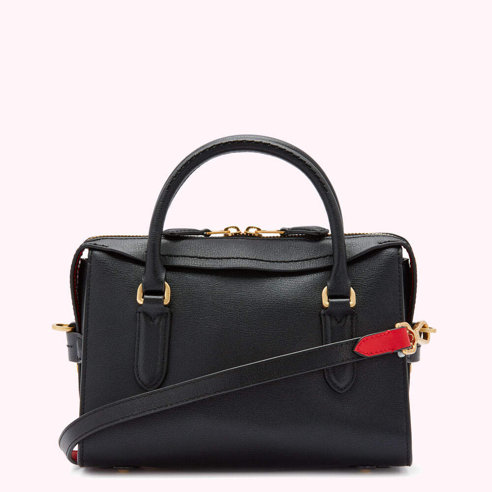 Black leather handbag with gold hardware and red accents.
