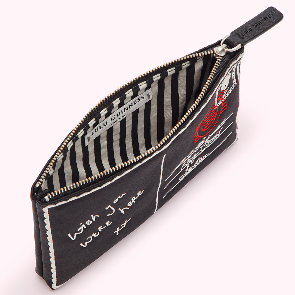 Black Lulu Guinness postcard-print zip pouch open to reveal black and white striped lining.