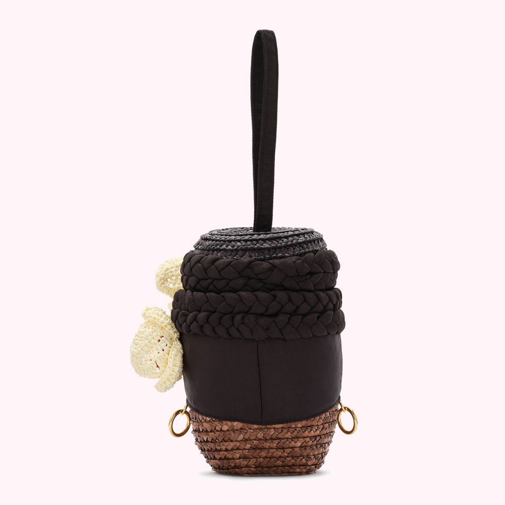 Brown woven handbag with cream embellishments and a top handle.