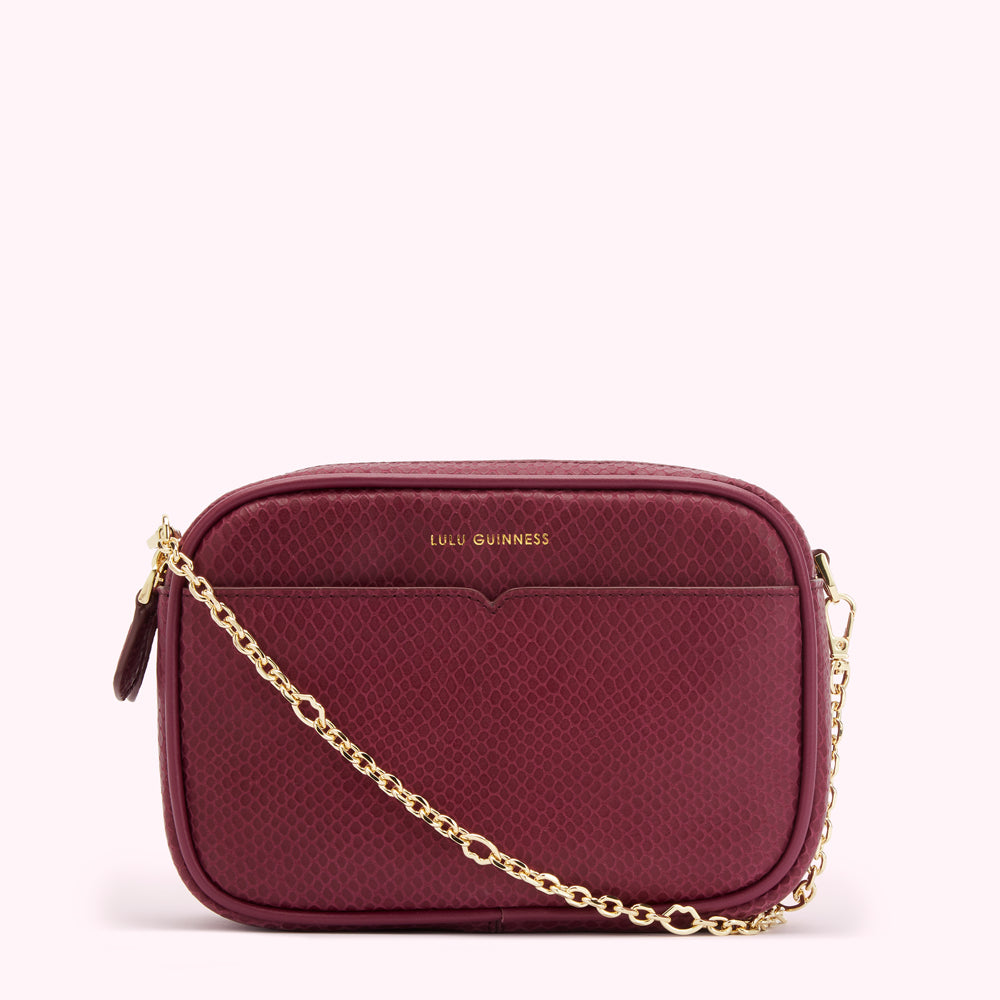 Burgundy snakeskin-textured crossbody bag with gold chain strap and Lulu Guinness logo.
