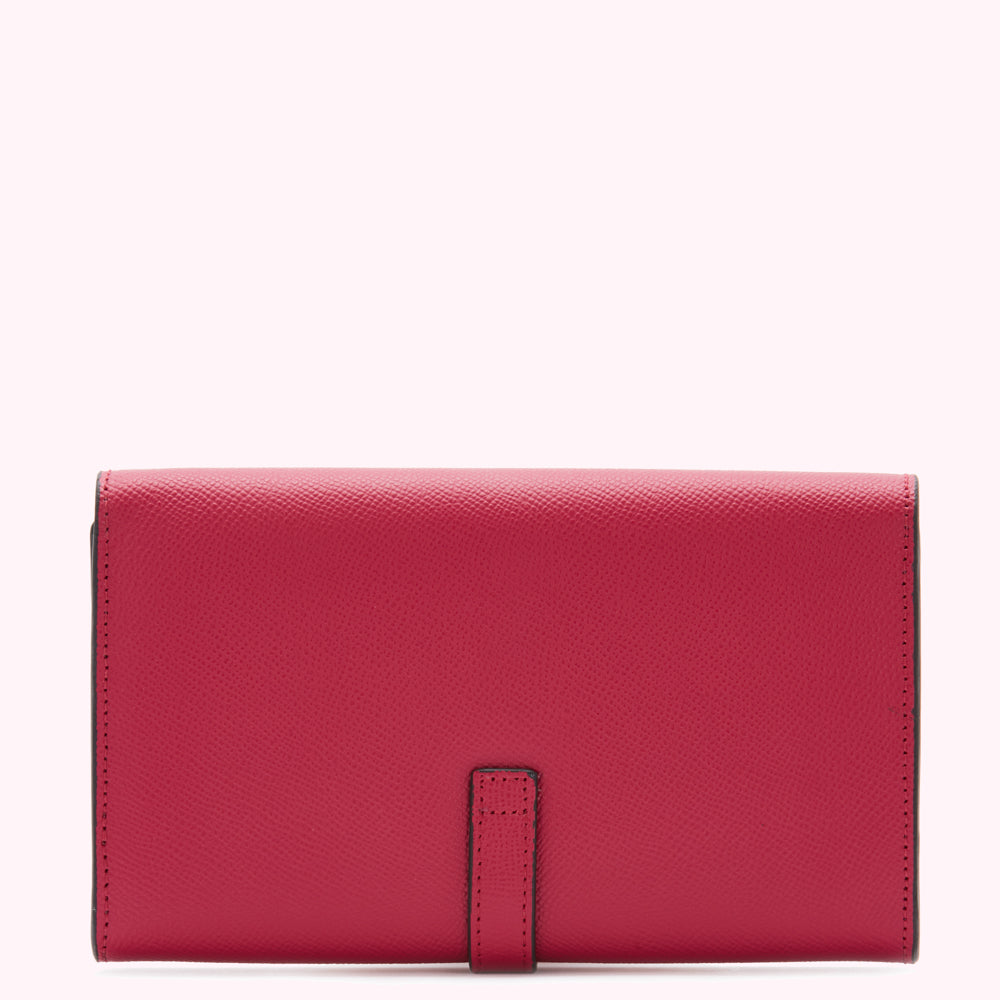 A pink leather wallet with a small black strap in the center against a white background.
