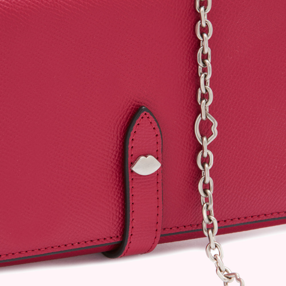 Close-up of a red leather wallet with a silver chain and lip-shaped detail.

