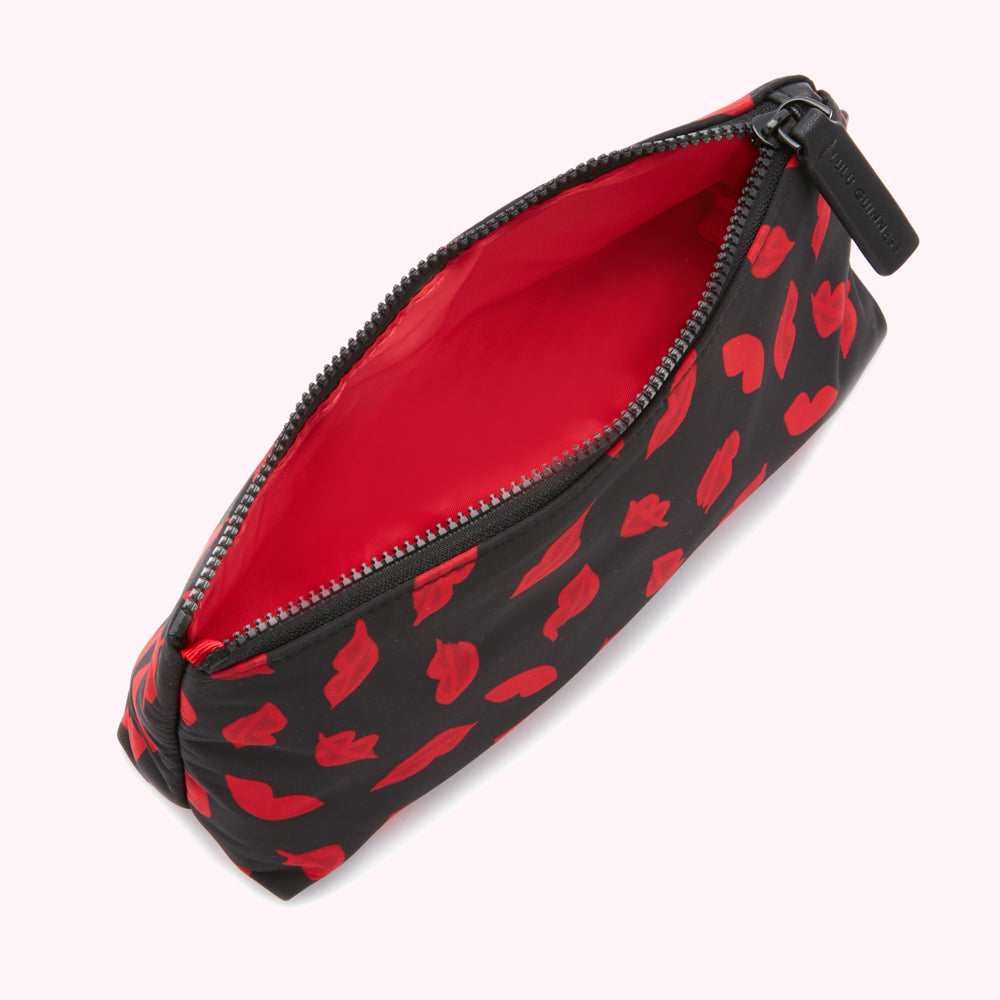 Open black makeup bag with red lips print and red interior.