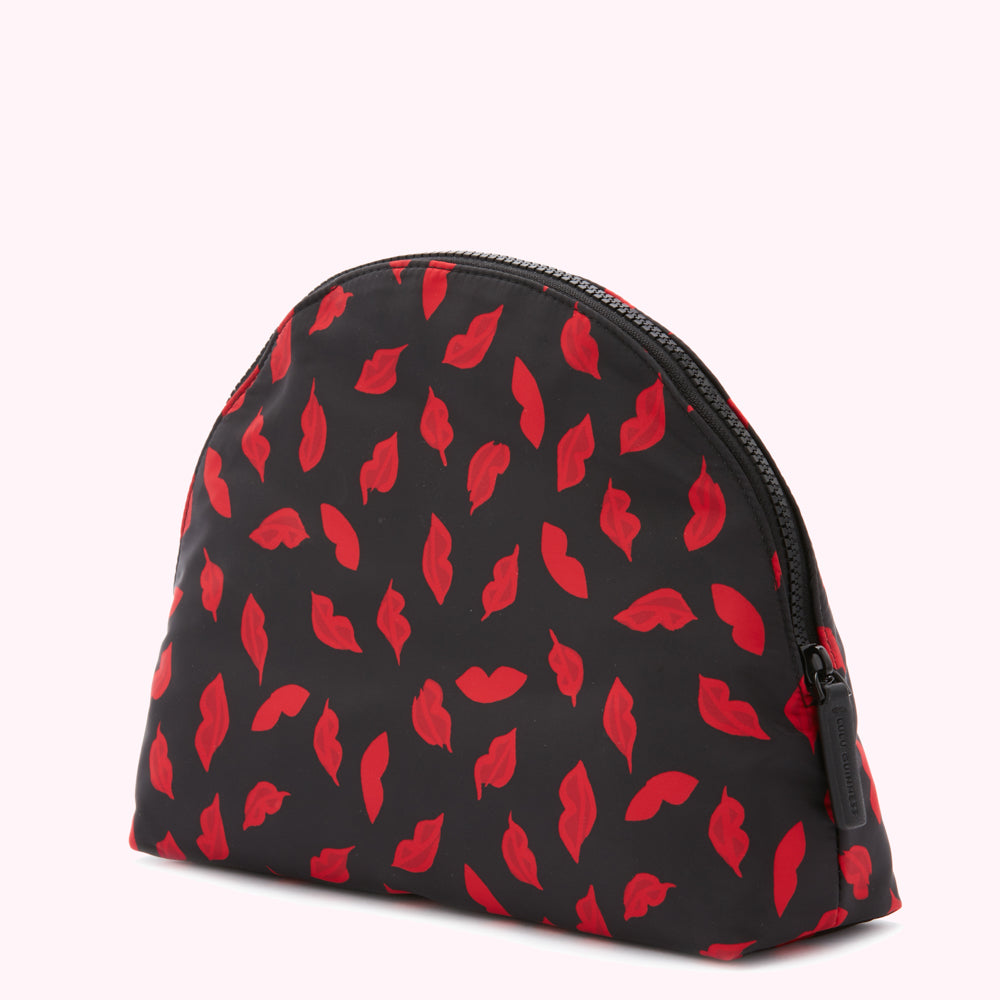 Black half-moon shaped cosmetic bag with a red lips print and zipper closure.
