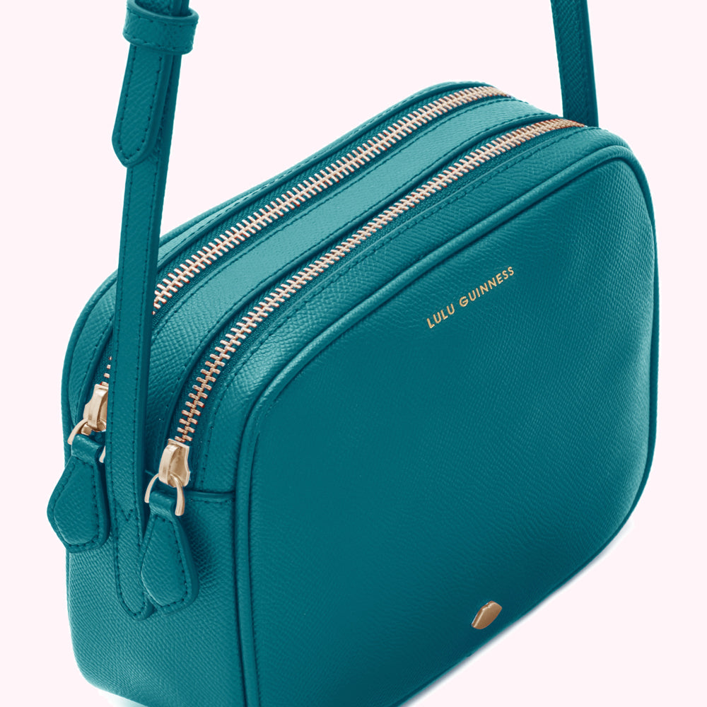 Teal Lulu Guinness crossbody bag with two zippers and gold hardware.
