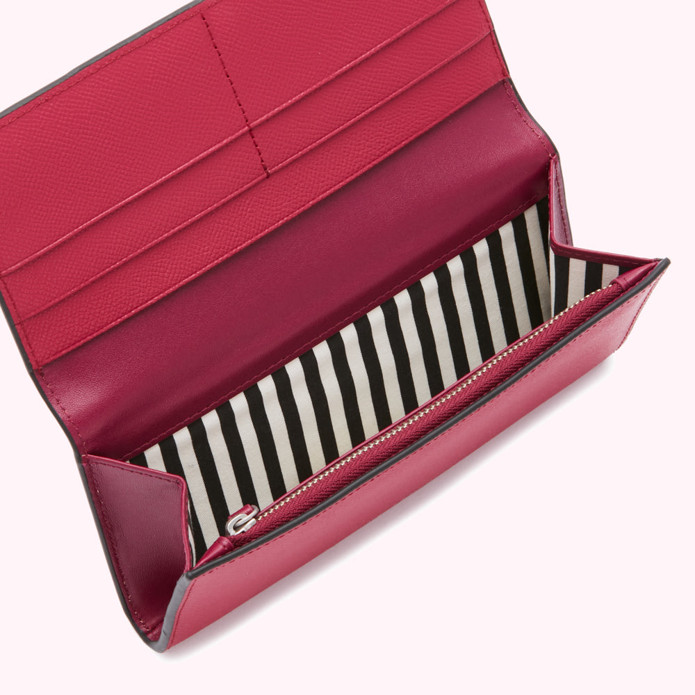 Open fuchsia leather wallet with black and white striped interior.
