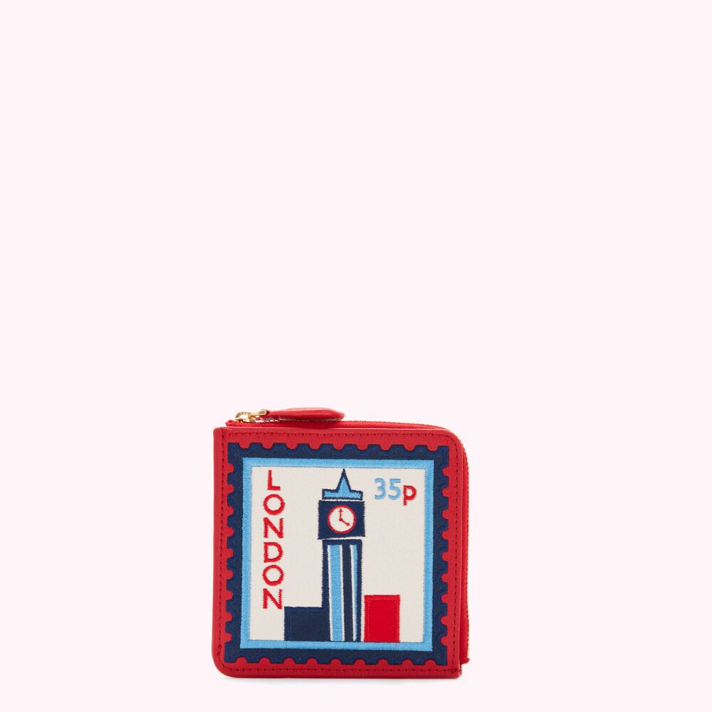 Red zip-around wallet featuring an embroidered London postage stamp design.
