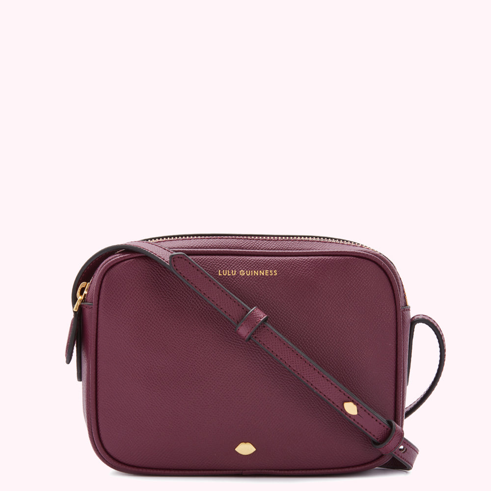 Burgundy Lulu Guinness crossbody bag with gold zipper and logo.