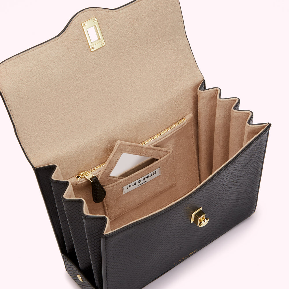 Open black Lulu Guinness handbag with beige interior and multiple compartments.
