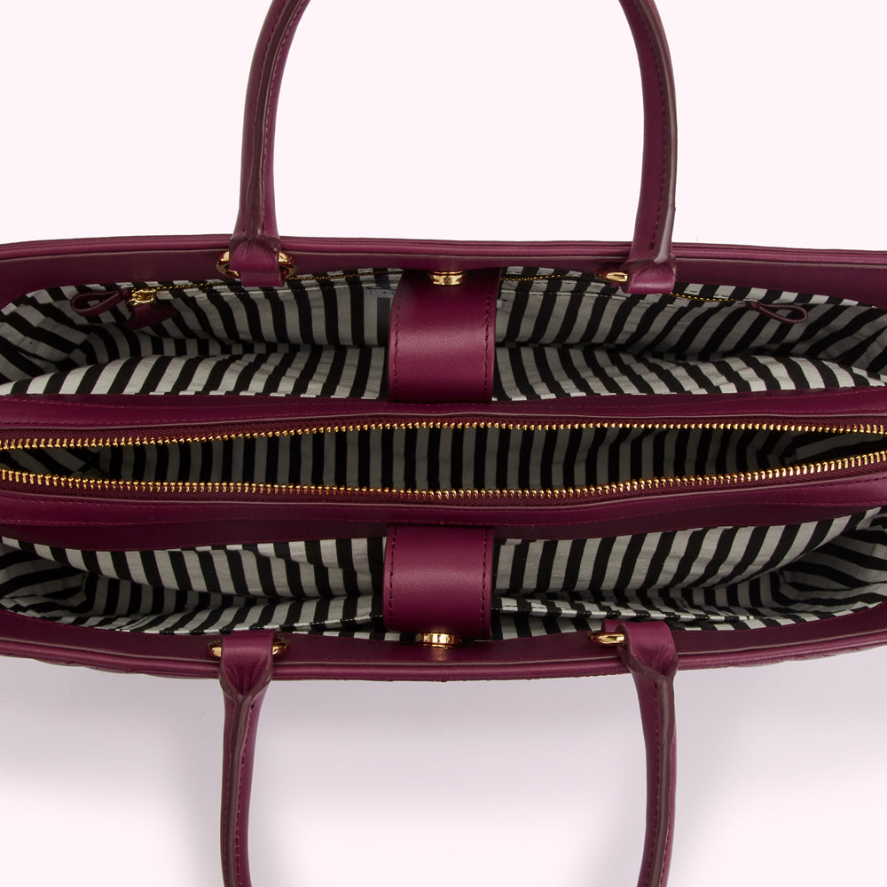 Open burgundy tote bag with black and white striped interior.