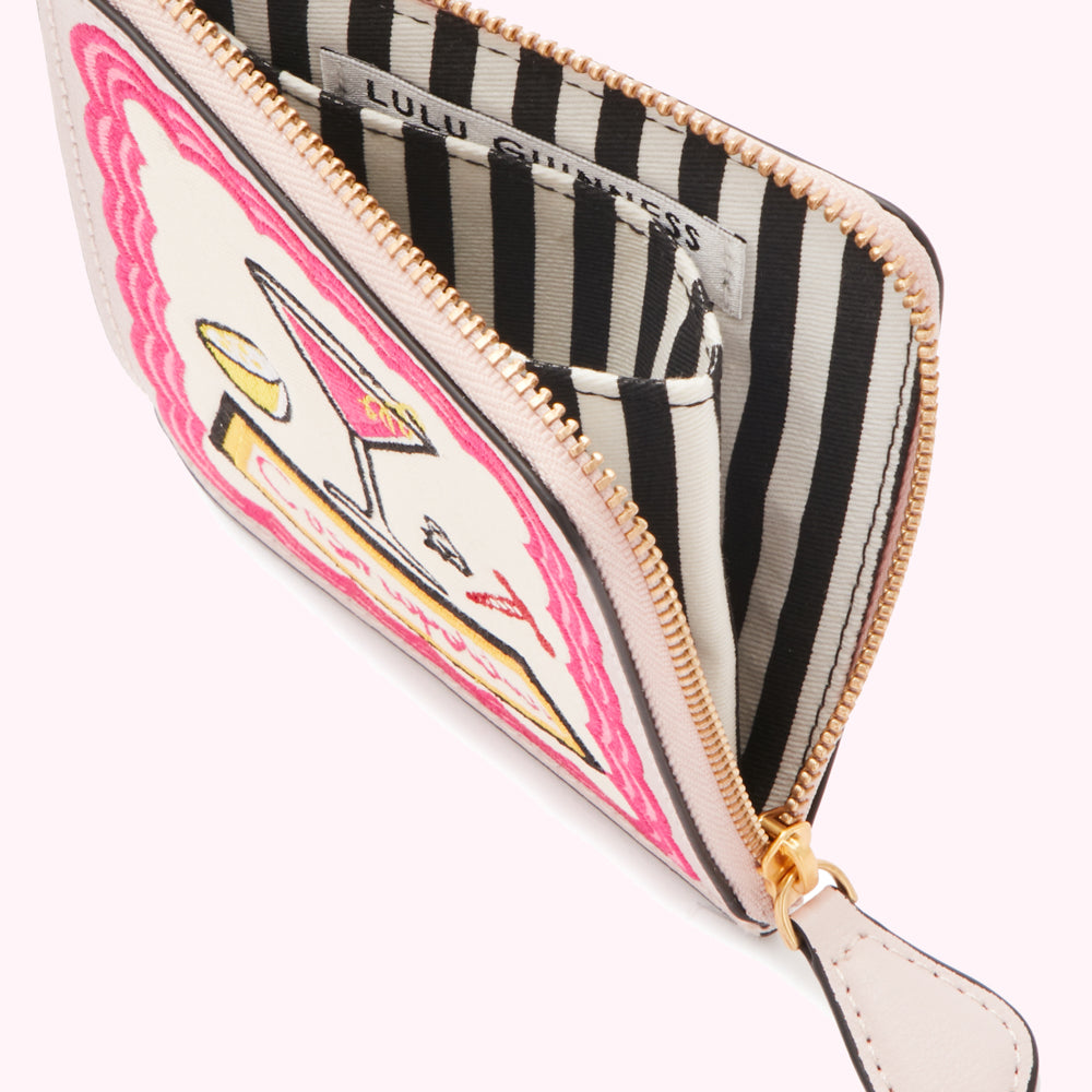 Open Lulu Guinness zip-around purse with cocktail-themed embroidery on a cream background and black and white striped interior.